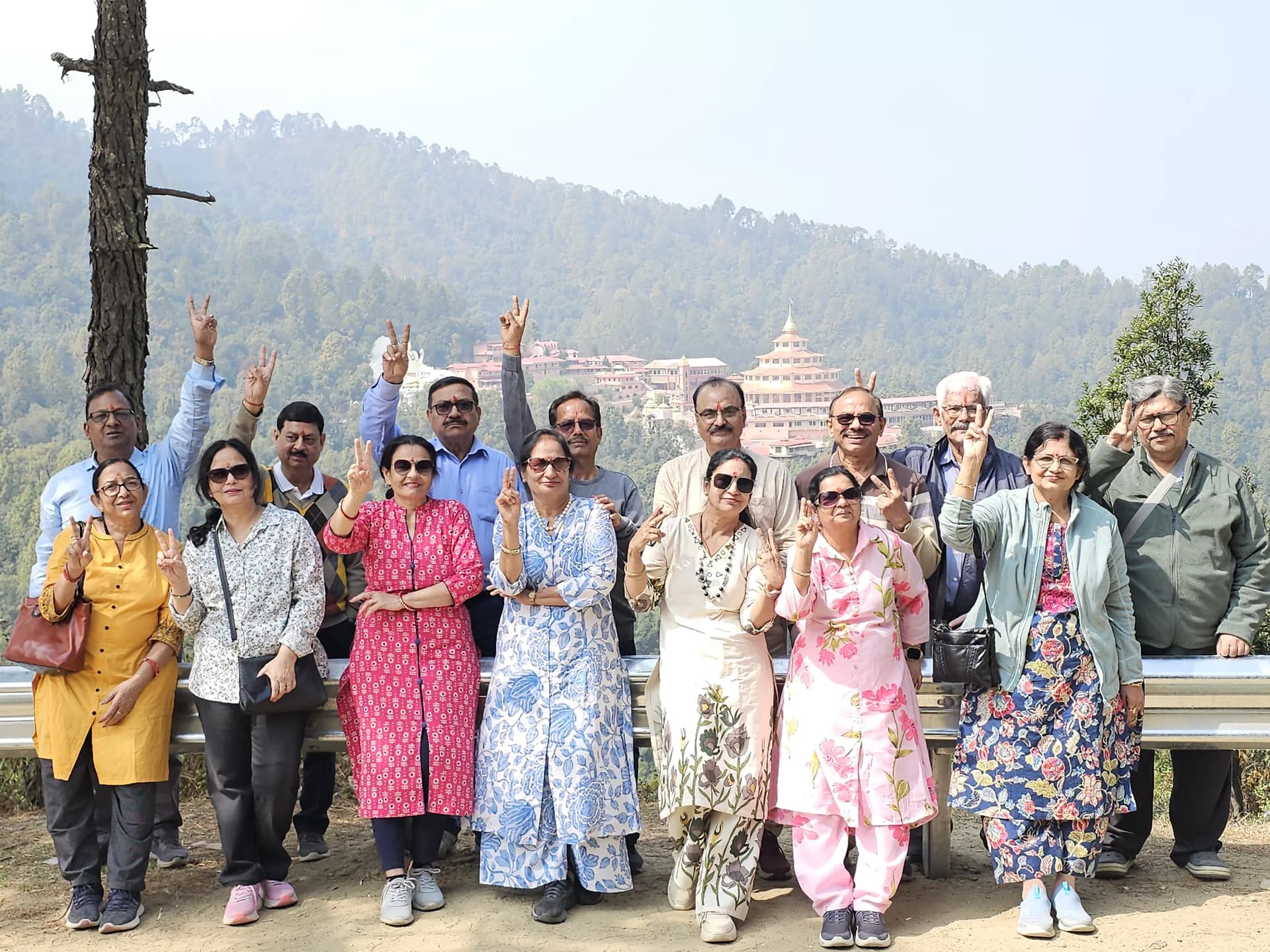 Cheerful devotees waving from a mountain ridge road with evergreen pine forest view